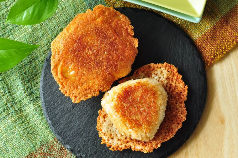 焼きチーズが羽根のようについているおにぎりがふたつ盛られた皿