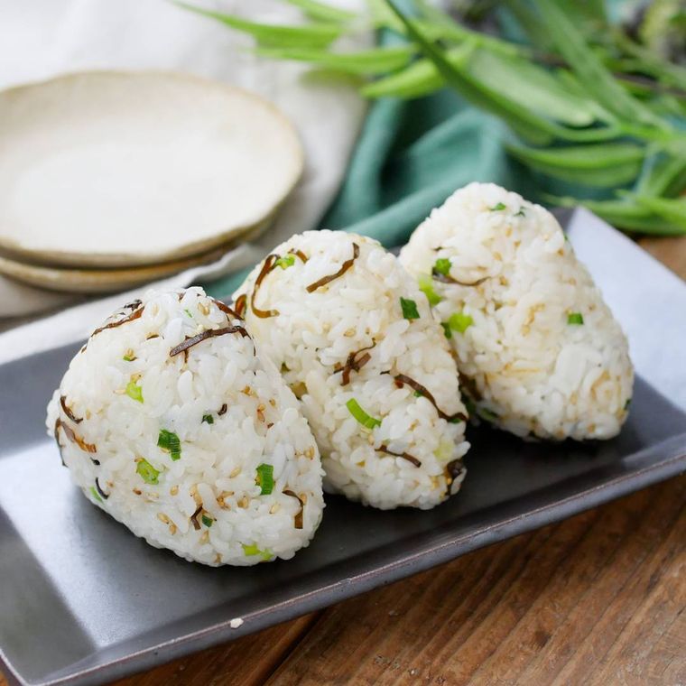 塩こんぶ入りのおにぎりが3個並ぶ黒い皿