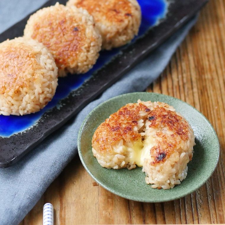 焼きおにぎりが並ぶ長皿と、半分に割られた焼きおにぎりがのっている小皿