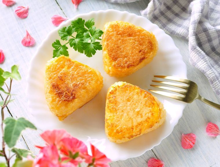 黄金色のフレンチトースト風おにぎりが3つのっている白い皿