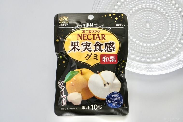 白い背景とガラスの器と黒いパッケージの和梨グミ