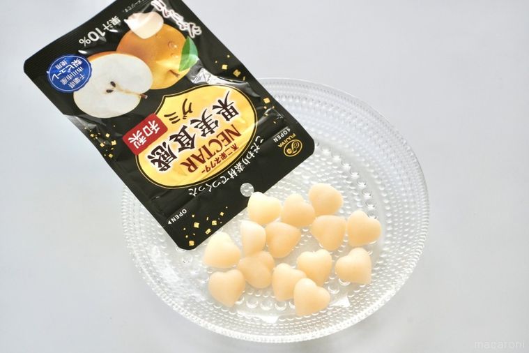 白い背景とガラスの器と黒いパッケージの和梨グミ