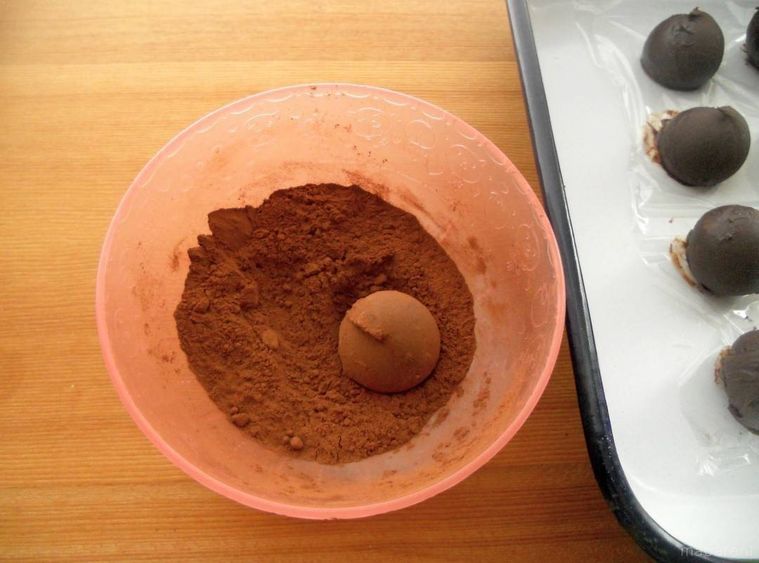 丸めたガナッシュクリームにココアをまぶしている様子