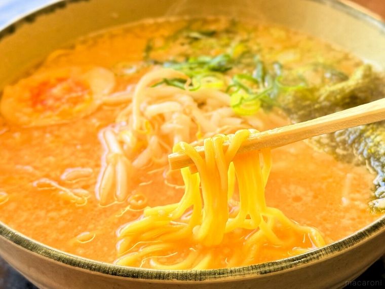「にんにくたまごラーメン」の麺を持ち上げている様子