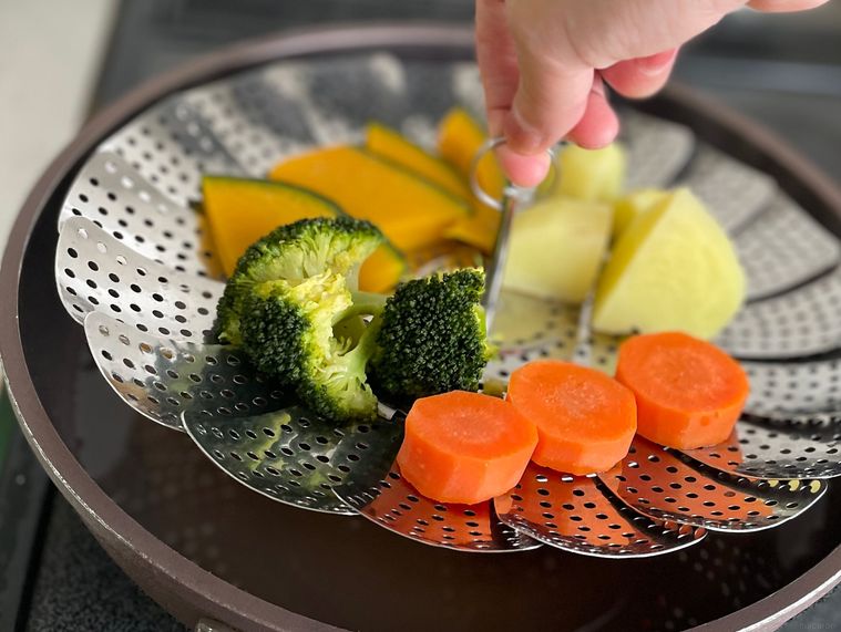 ダイソーの蒸し器の中心を手で持ち上げているところ