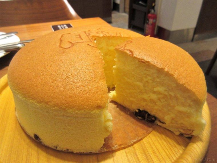 ウッドプレートにのせられた超・焼きたてチーズケーキをカットした様子