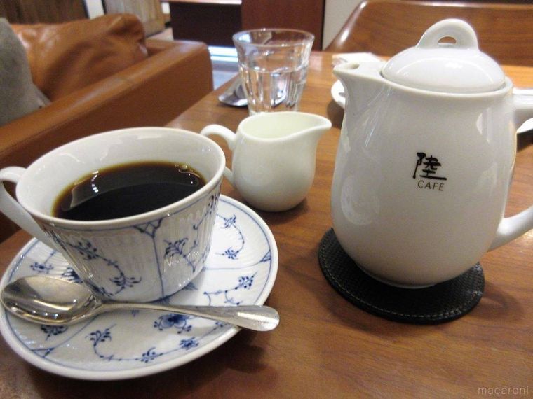 コーヒーカップに入った陸カフェ四大陸ブレンドHOTとコーヒーポット、ミルク