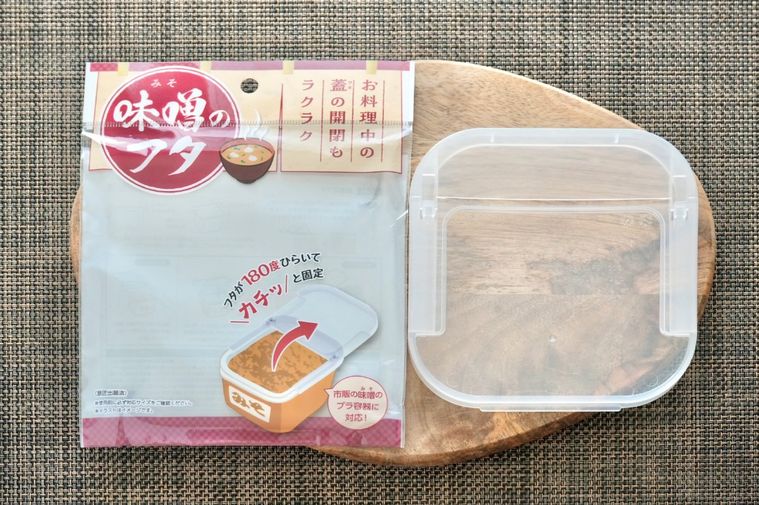 木のカッティングボードにのった味噌用のふたとパッケージ