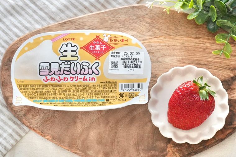 木のカッティングボードにのった生雪見だいふくとストライプの布とグリーンといちご