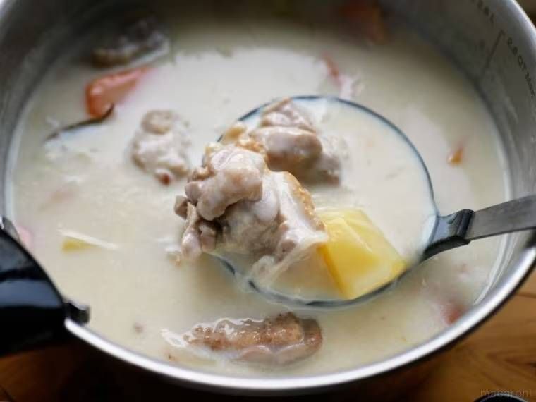 鍋に入ったシチューをお玉ですくっている様子