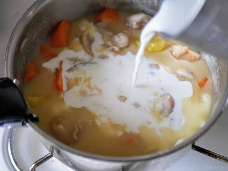 シチューに牛乳を加えている様子