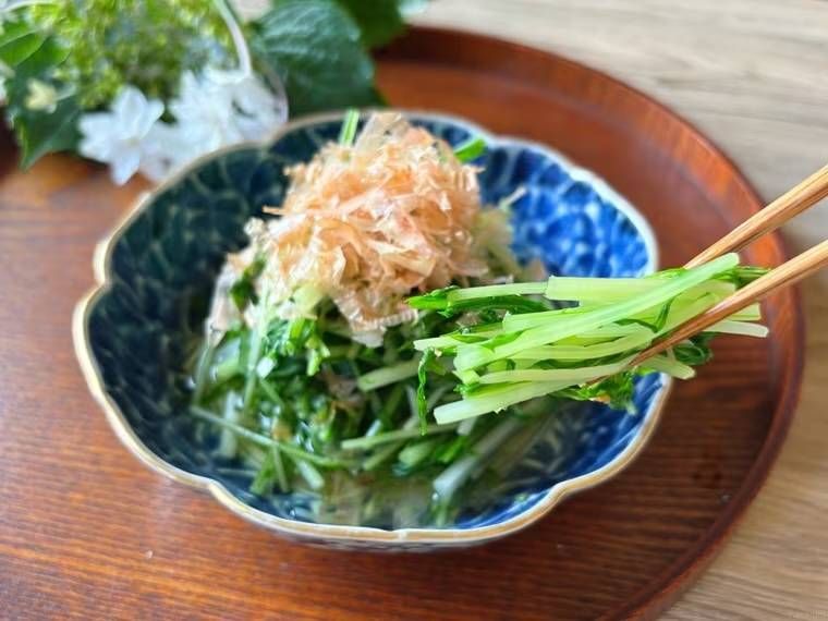 水菜のおひたしを箸で持ち上げている様子