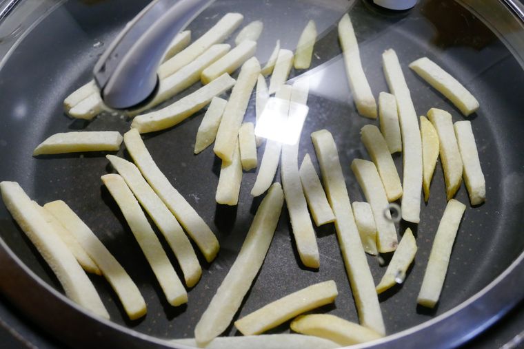 フライパンに冷凍ポテトを広げて蒸す様子