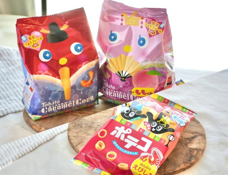 白いテーブルクロスと木のカッティングボードにのったひなまつりパッケージのお菓子