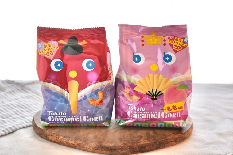 白いテーブルクロスと木のカッティングボードにのったひなまつりパッケージのお菓子