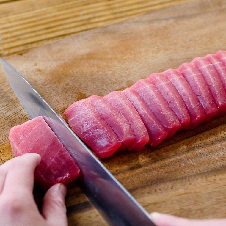 マグロの刺身を包丁で切っている様子