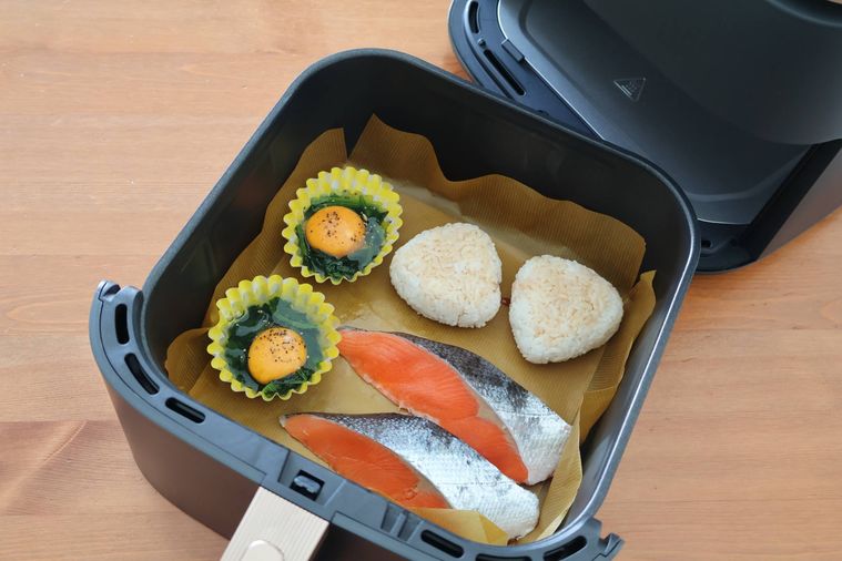 焼きおにぎり、鮭、巣ごもり卵をノンフライヤーに入れている