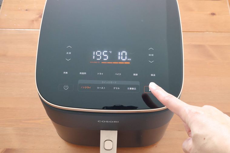 ノンフライヤーのボタンを押している