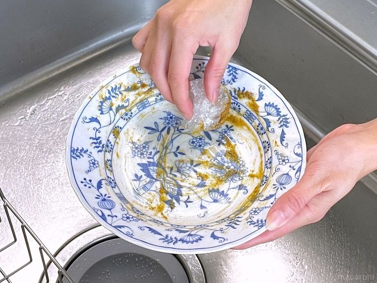 カレーがついた皿をラップで拭いている様子