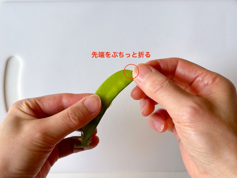 さやえんどうの先端を折る様子