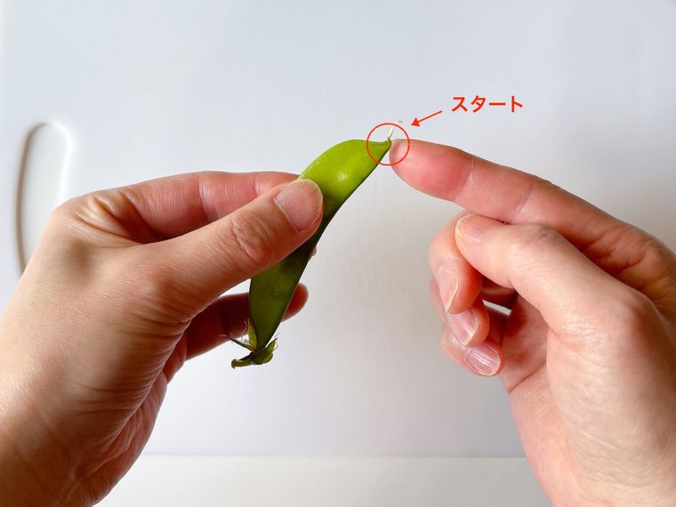 さやえんどうの筋を取る部分を指した様子