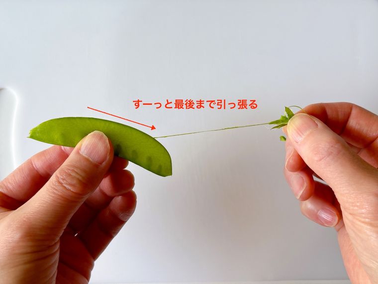 さやえんどうの筋を引っ張る様子