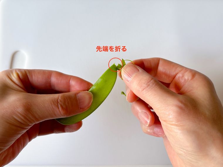 さやえんどうの先端を折る様子
