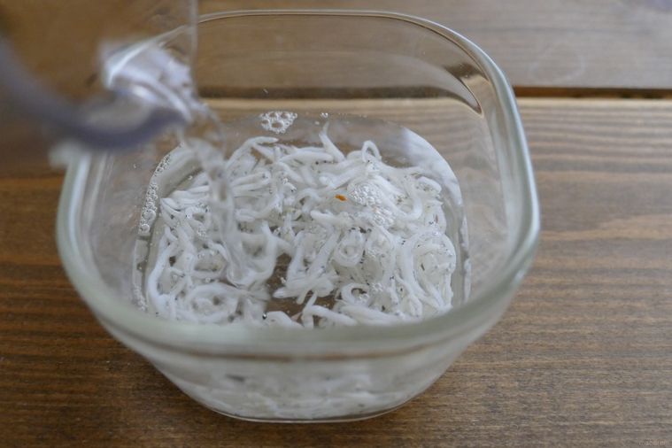 しらすが入っている耐熱容器に水を注ぐ様子