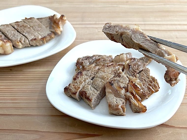 ステーキを箸で持ち上げている様子