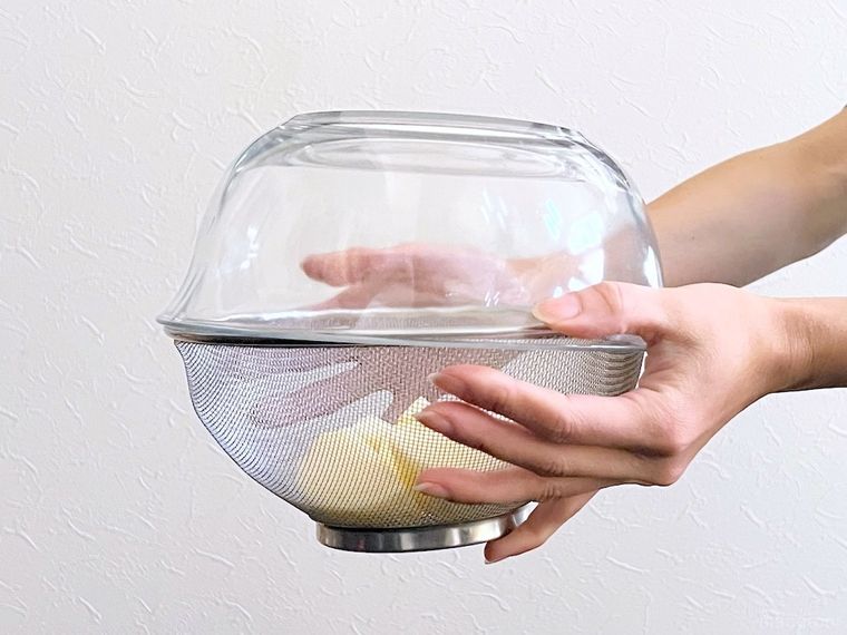 じゃがいもが入ったざるを振っている様子