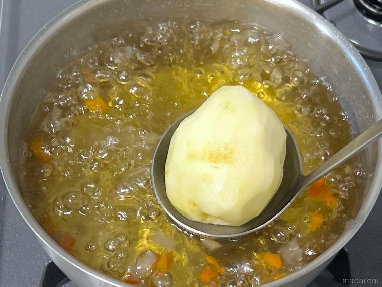 じゃがいもをコスープに入れようとしている様子
