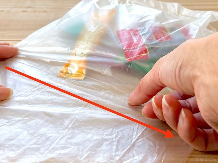 ポリ袋に爪で線を付けている様子