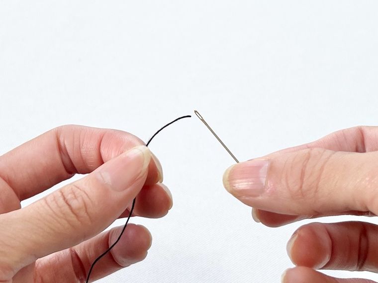 針に糸を通そうとしている様子