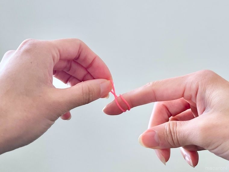 指に輪ゴムをかけている様子