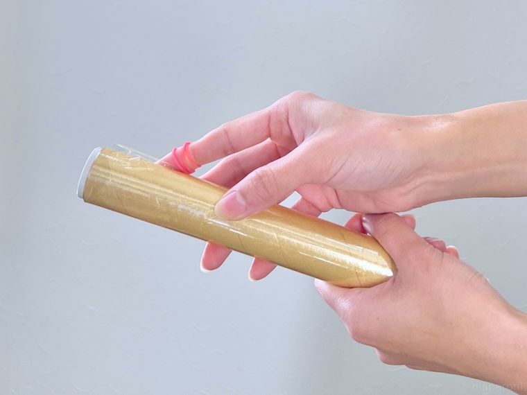 輪ゴムをかけた指でラップをこすっている様子