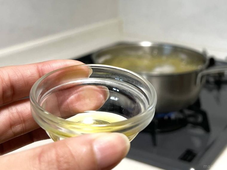 小皿に入ったオリーブオイルを手で持っているところ