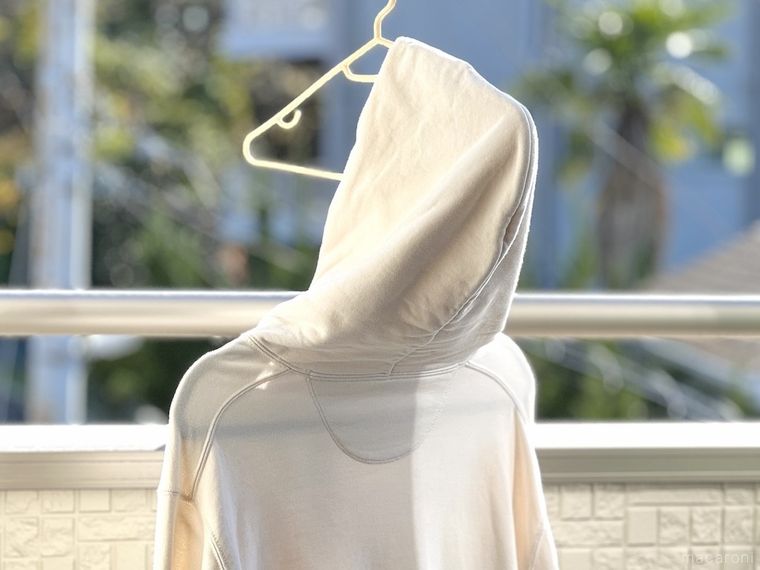 ハンガーにかけた白いパーカー