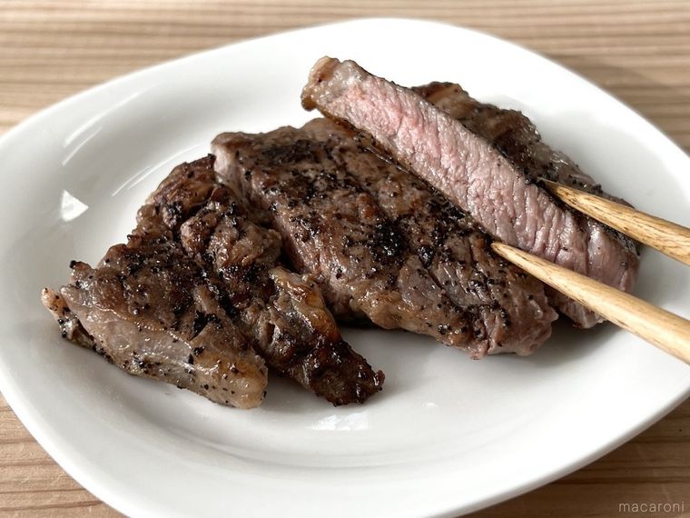 白い皿に盛り付けたステーキを箸上げしている様子
