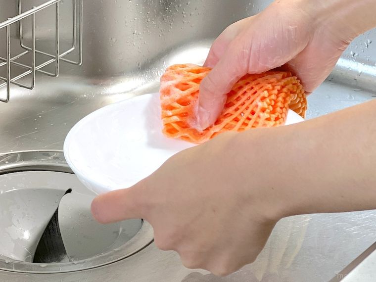 フルーツネットをスポンジ代わりにして食器を洗っている様子