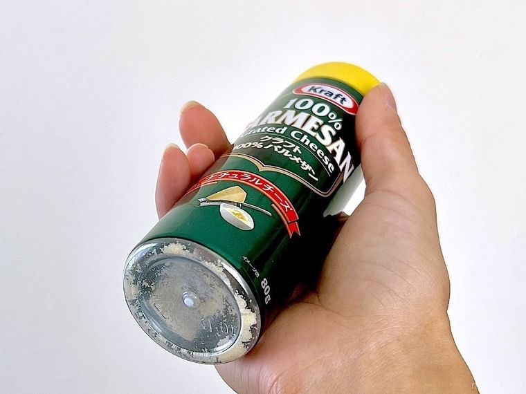 右手に持った粉チーズの容器