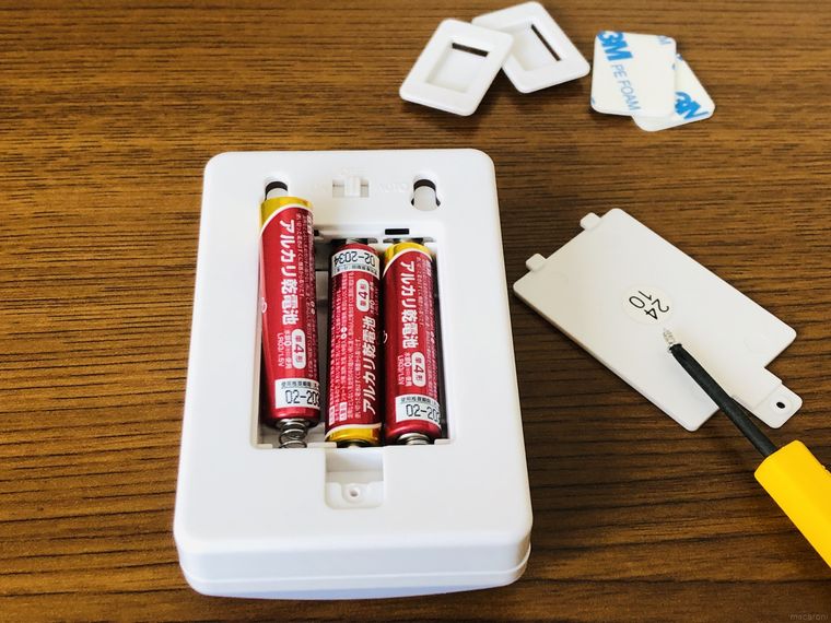 センサーライトの裏面のカバーを開けて電池を入れている