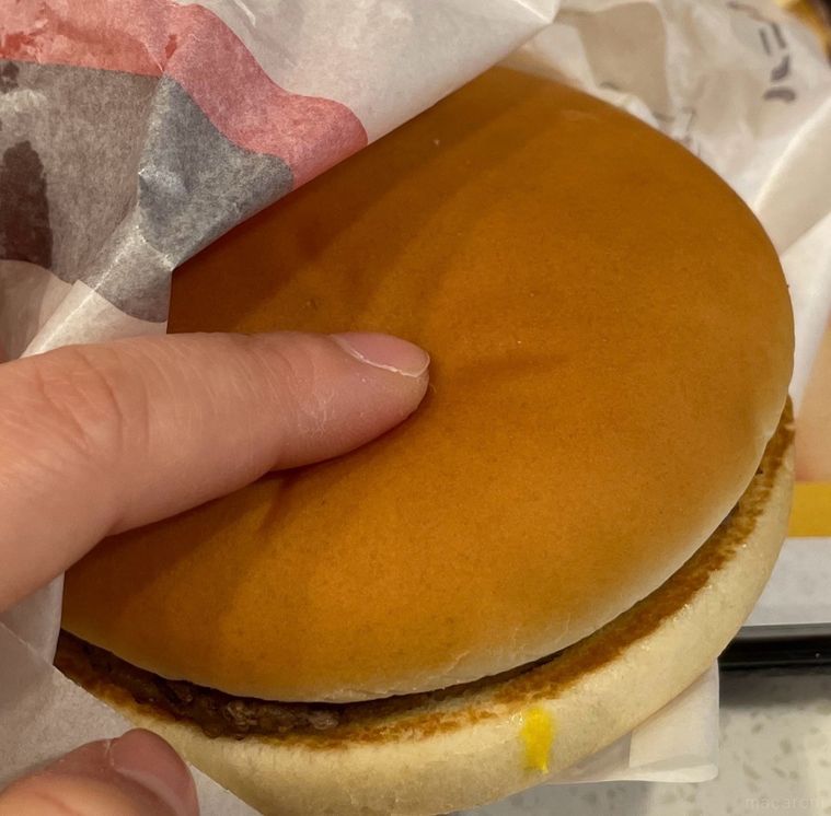 注文したハンバーガーのバンズを押している