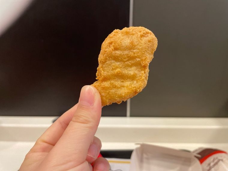 マクドナルドで注文したチキンマックナゲットを手に持っている