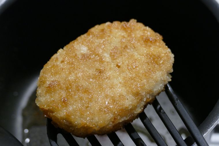 コロッケをフライ返しで取り出す様子