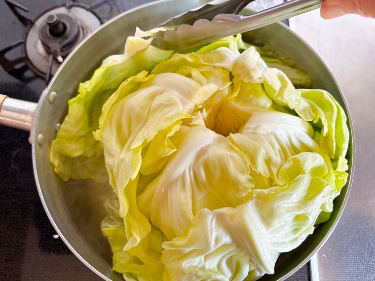 ゆでたキャベツをトングで取り出す様子