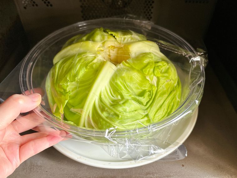 キャベツをボウルに入れてラップをし電子レンジに入れる様子