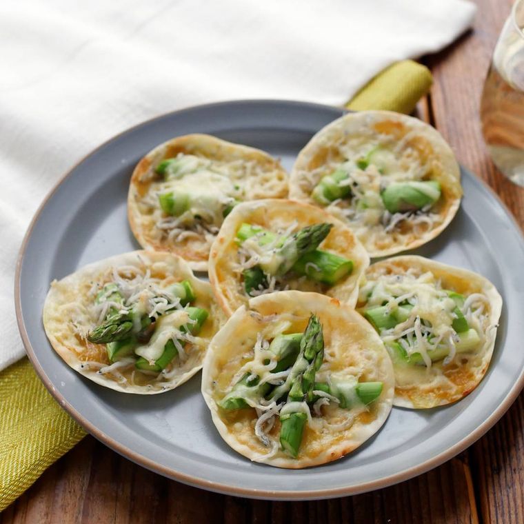 グレーの丸皿に盛り付けたしらすとアスパラガスのミニピザ