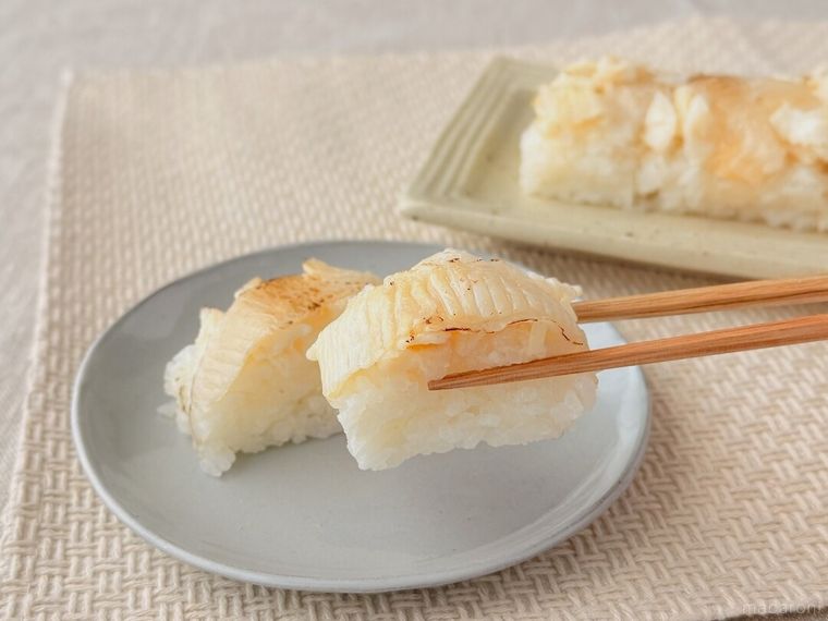 成城石井自家製 えんがわたっぷり炙り押し寿司を箸で持っている様子