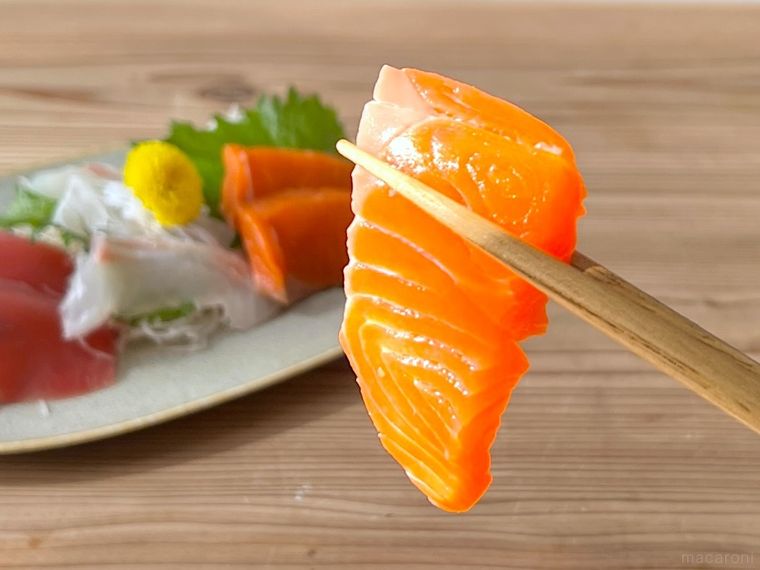 刺身を箸で持ち上げている様子