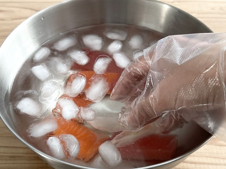 食塩水の中で刺身をかき混ぜている様子